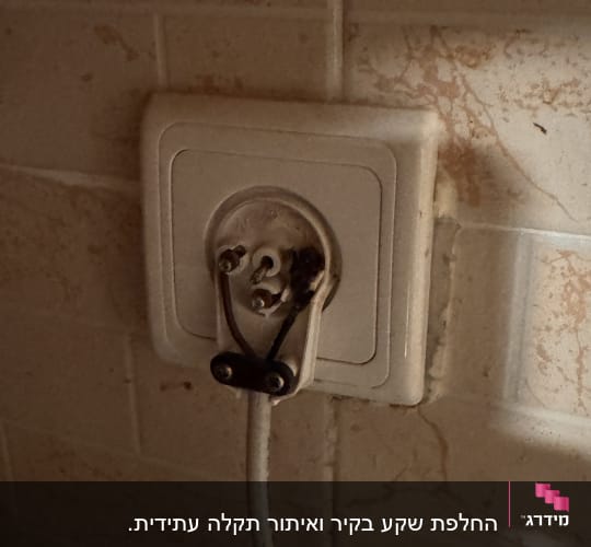 שקע חשמלי עם חוטים חשופים על קיר
